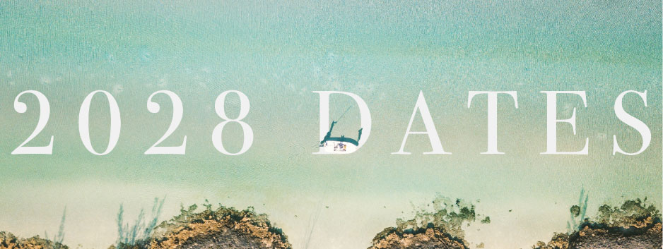 Graphic with large white text '2028 DATES' over a turquoise sea and sandy shore, with a small sailboat in the water.